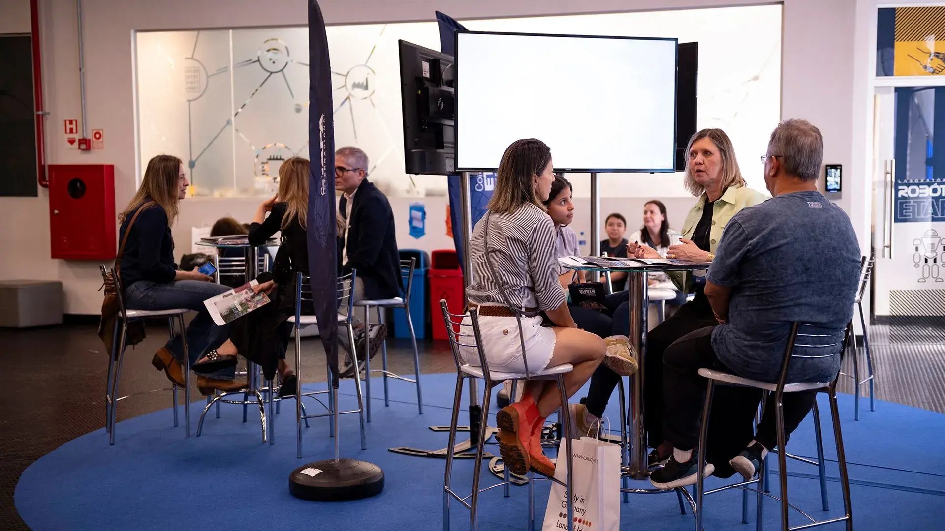 Professores sentados conversando na Feira de Universidades Internacionais 2024
